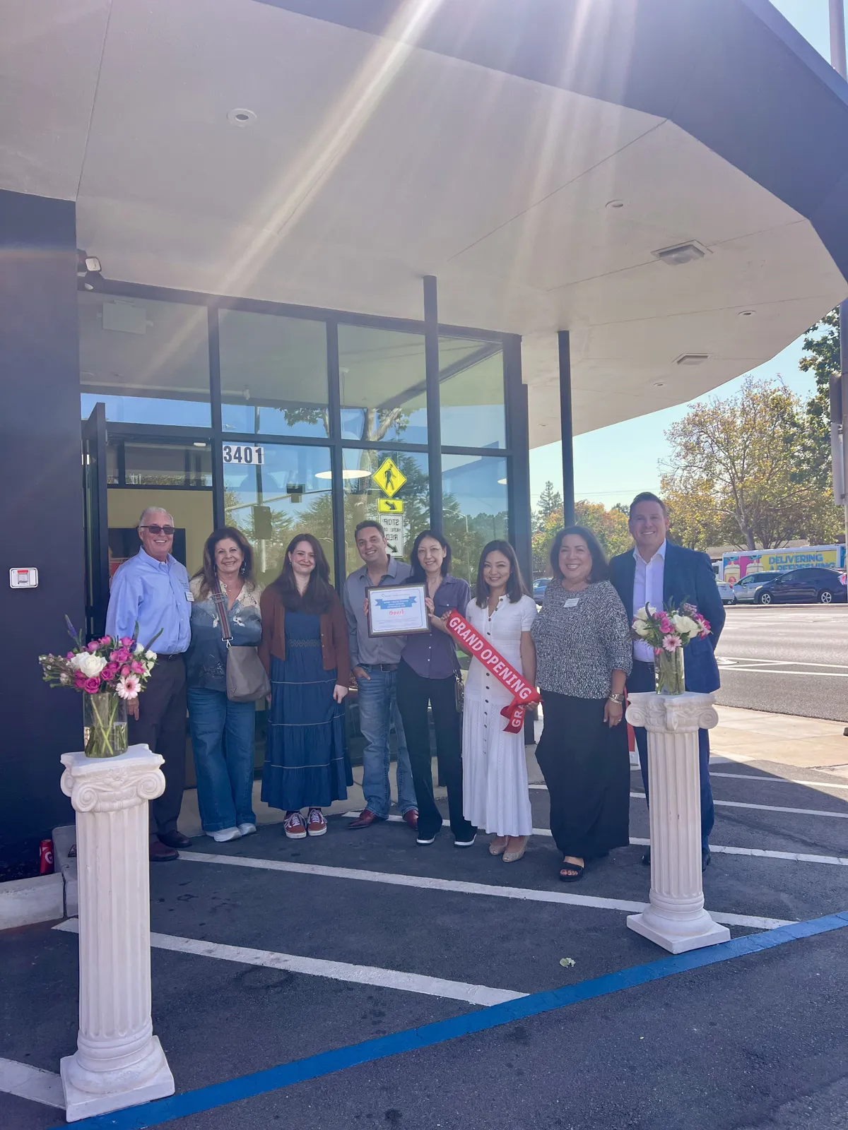 Opus 1 Music Studio team and guests from the Palo Alto Chamber of Commerce holding the ribbon cutting certificate in front of the Palo Alto campus.