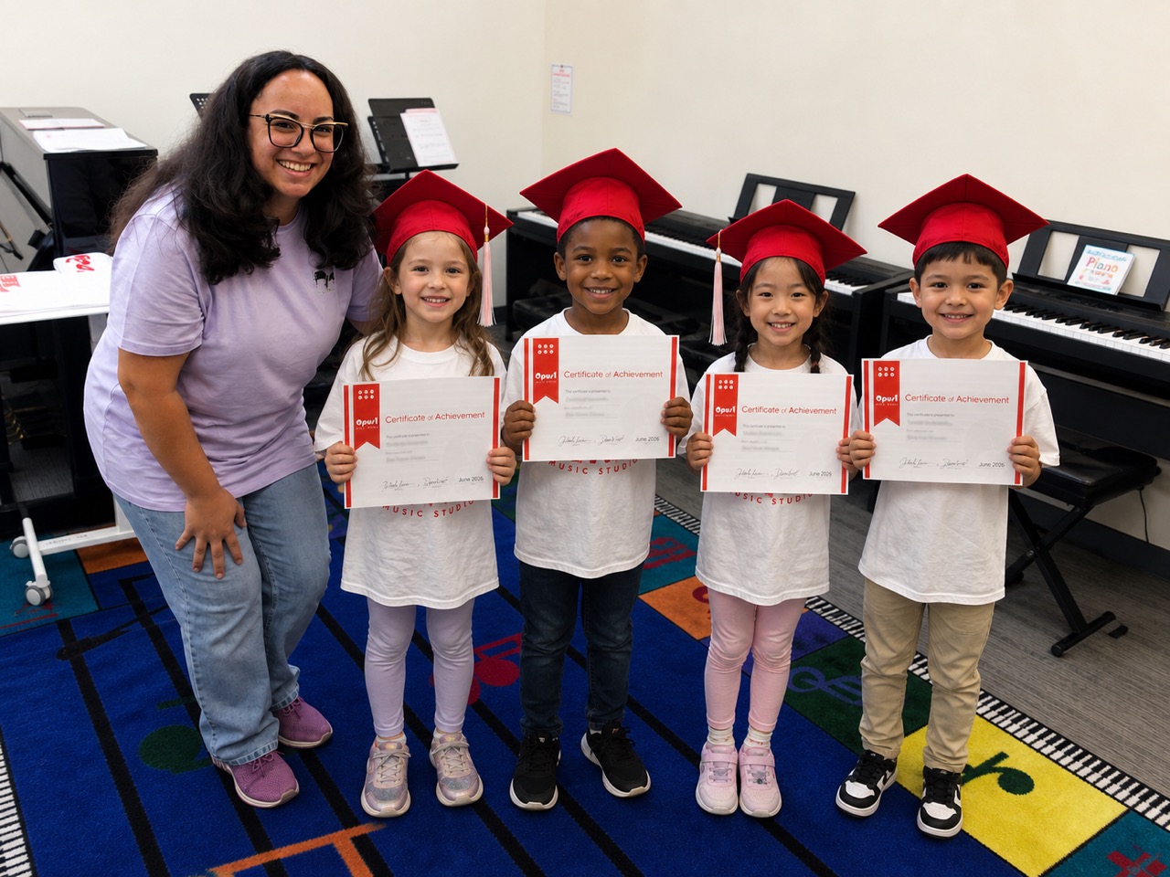 Opus 1 teacher with four My First Piano graduates in red caps holding Certificates of Achievement